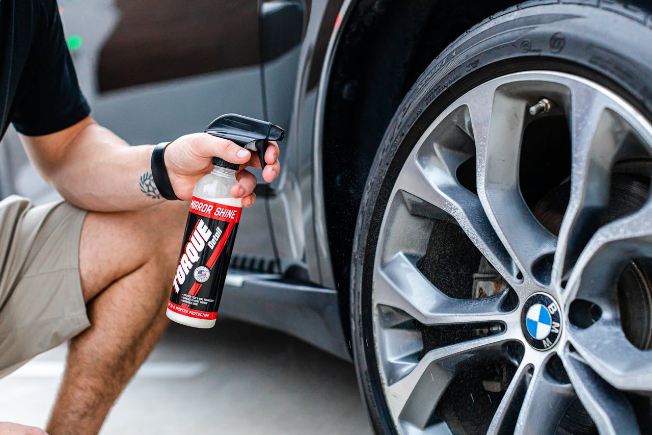 A person is applying tire shine on a BMW wheel, showcasing a luxury cars shiny finish.